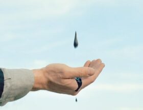 Sulla copertina di Dove la luce di Carmen Pellegrino c'è una mano tesa che raccoglie pioggia nera che cade da un cielo velato da nuvole